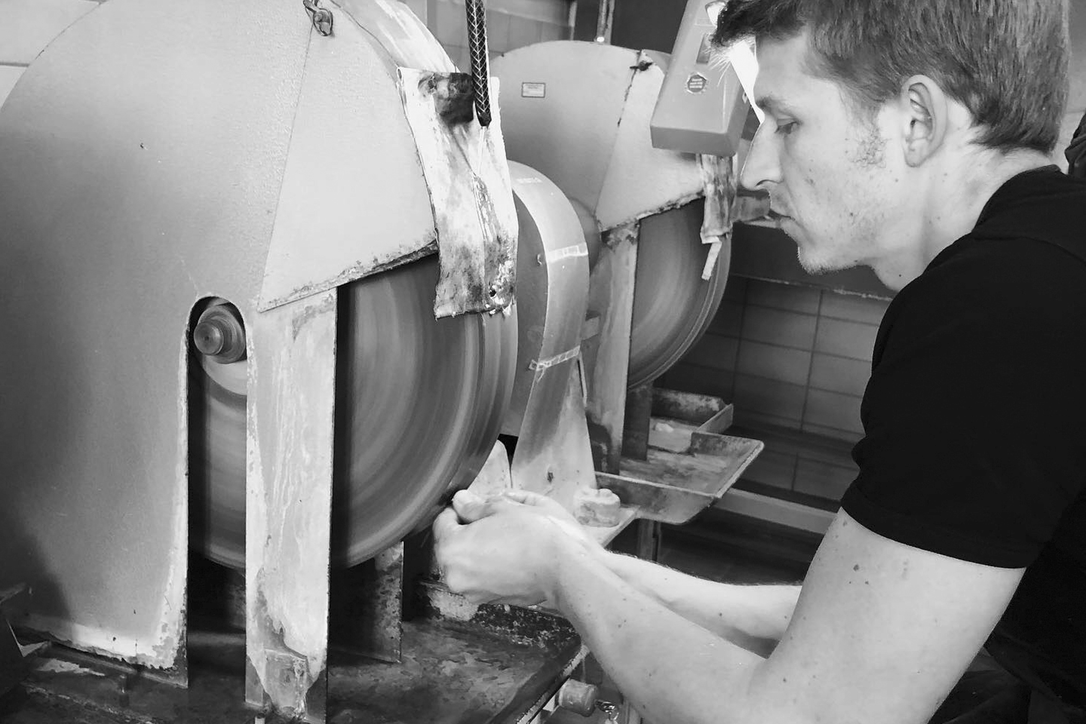 the artist cutting a stone on a grinding wheel